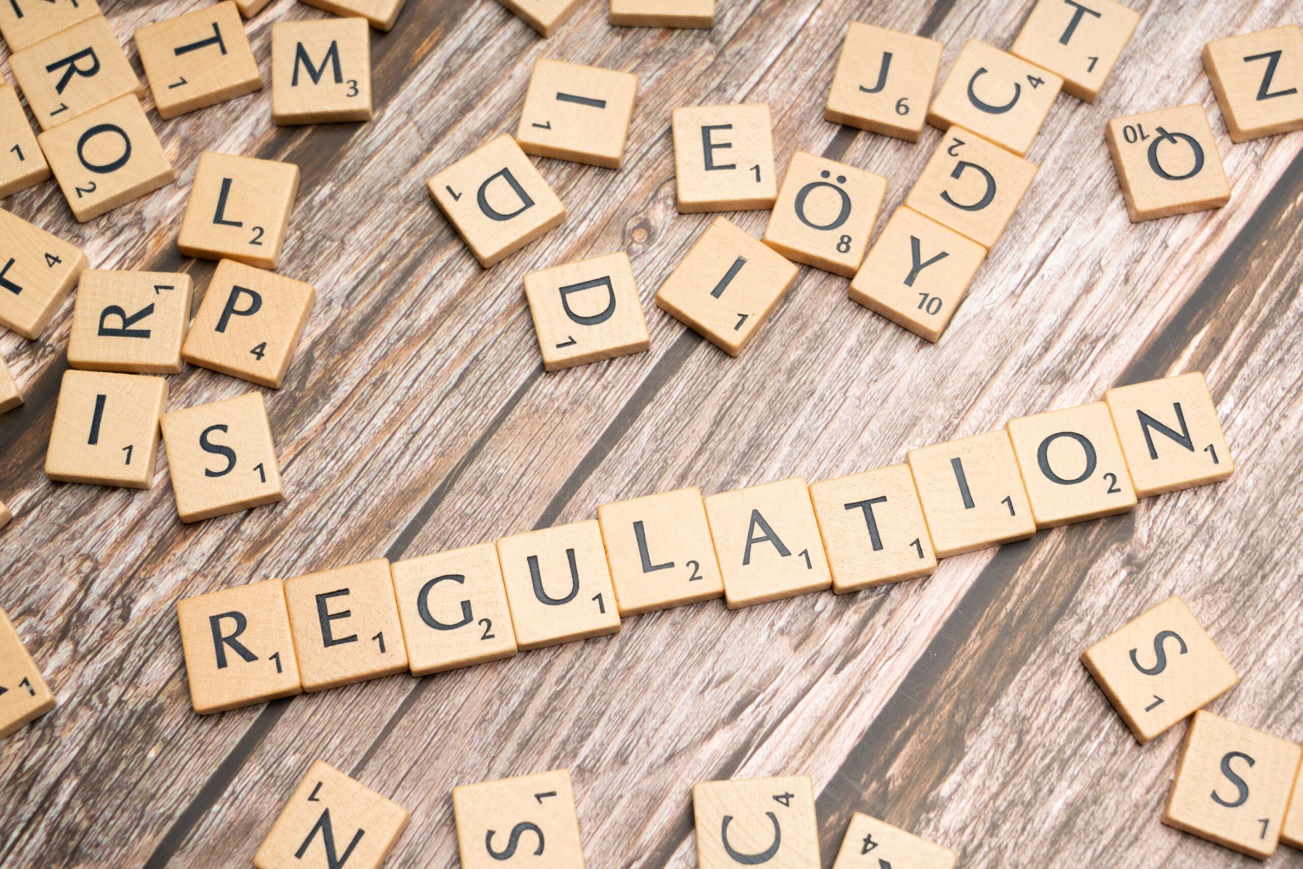 Fa betűkockák "Regulation" (szabályozás) felirattal, AI Act szabályozás szimbóluma